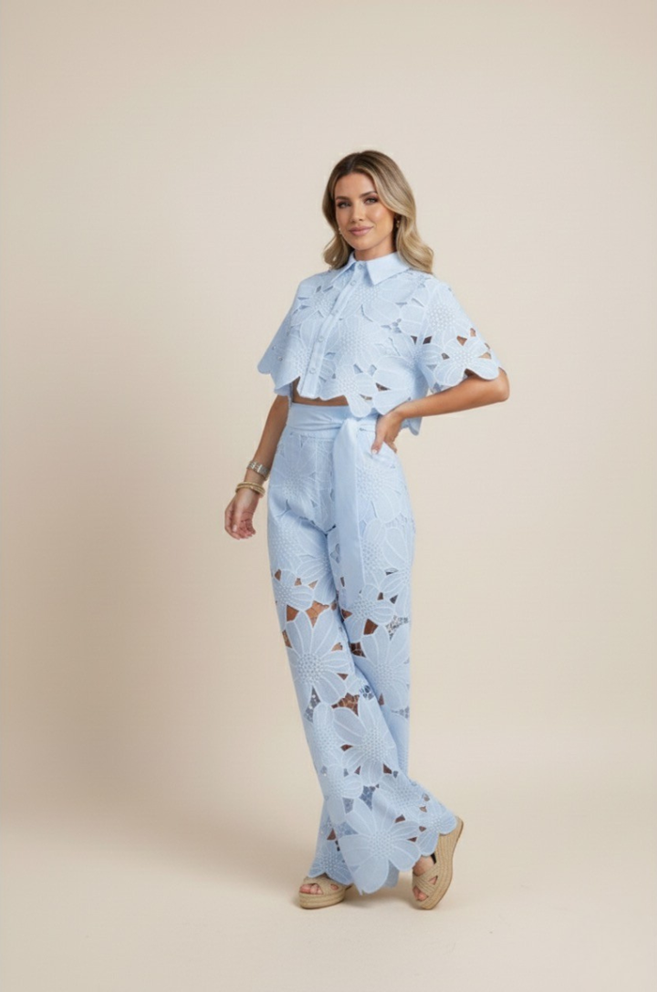 Women's elegant floral embroidered button-up top and wide-leg trousers matching set.