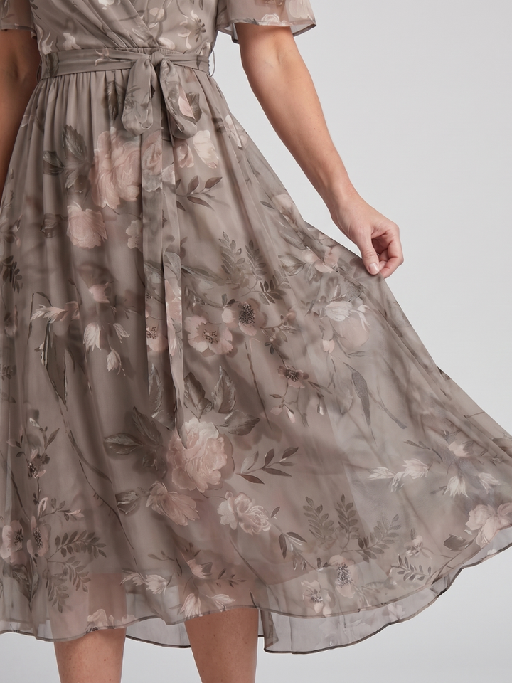 Flowy women's floral midi dress, ideal for summer. Features flutter sleeves, V-neck, and a gathered waist.