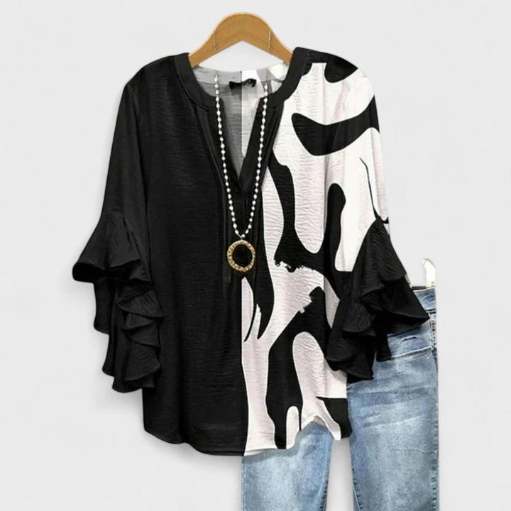 Delicate women's V-neck blouse in a vibrant floral print, enhanced with short ruffle sleeves for a chic look.