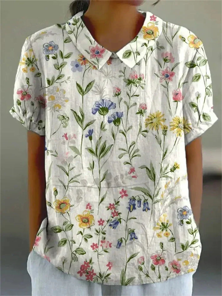 Elegant women's short sleeve blouse with a charming Peter Pan collar and vibrant floral print.