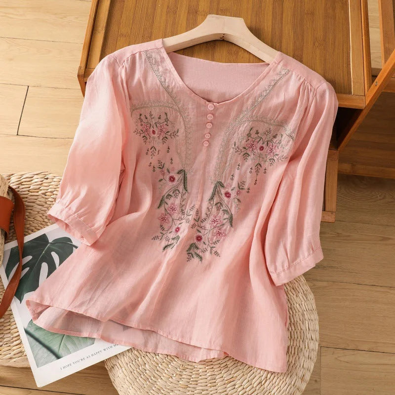 Relaxed fit women's blouse featuring a vibrant floral pattern, V-neck, and comfortable 3/4-sleeves. Spring fashion.