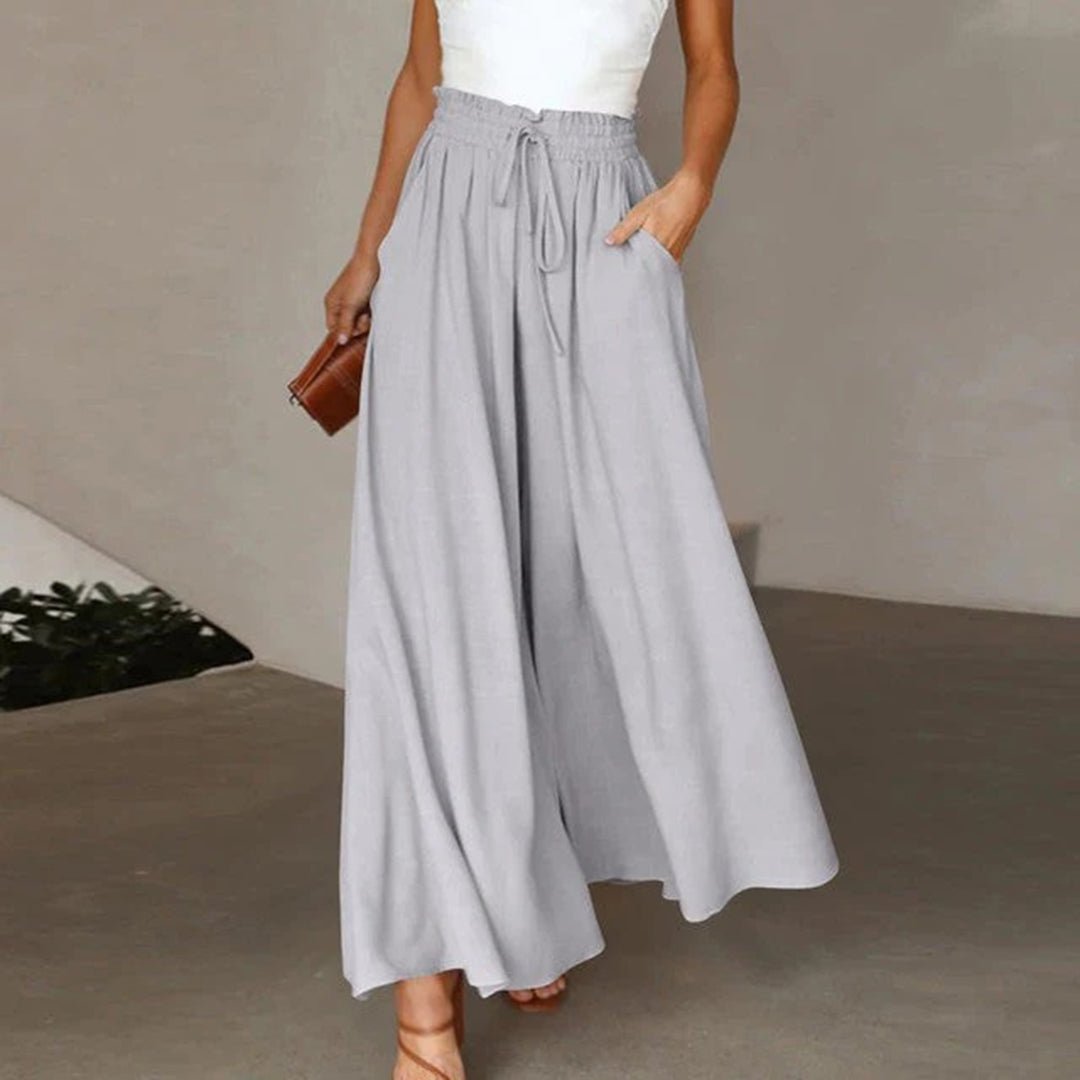 Elegant women's flowy wide leg trousers with a high waist and drawstring, ideal for a chic summer look.