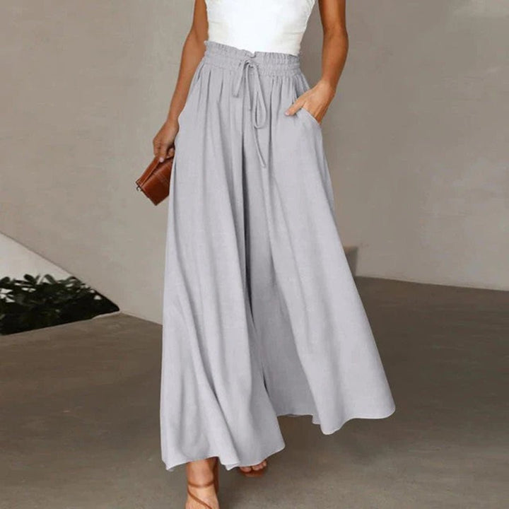 Elegant women's flowy wide leg trousers with a high waist and drawstring, ideal for a chic summer look.
