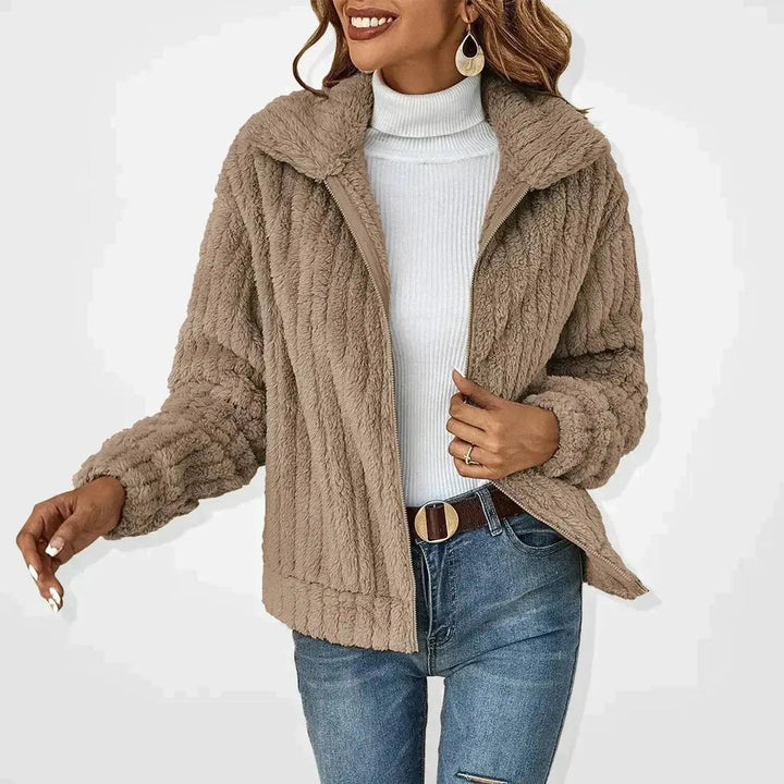 Close-up of a women's fluffy zip-up quilted jacket, highlighting its soft texture & cozy design for fall.