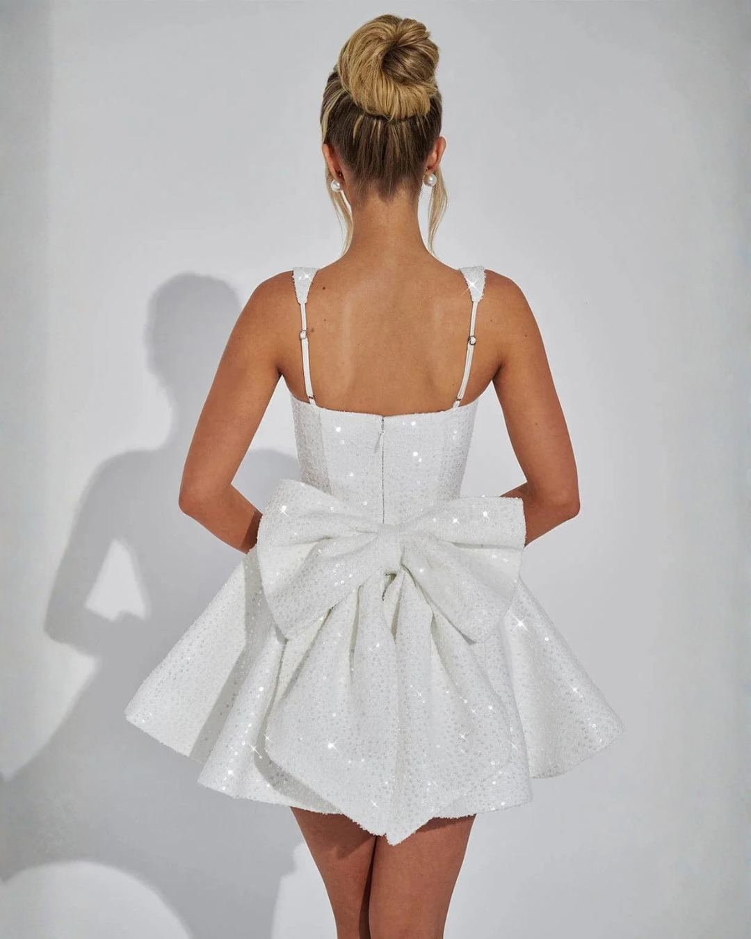 Women's sequin square neck mini dress with a fashionable detachable bow. Glamorous party & evening wear.