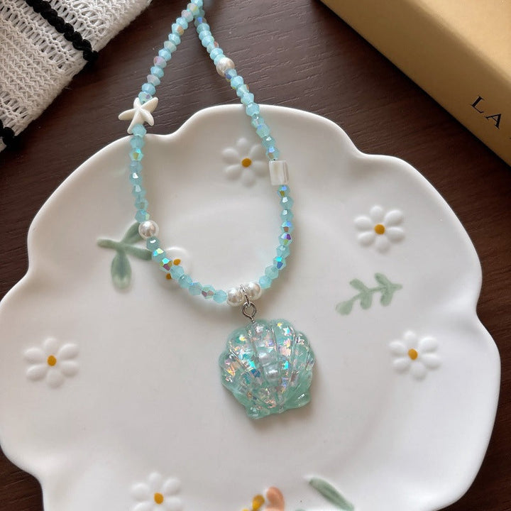 Detailed metal fish tail pendant with glitter on a delicate bead chain necklace.