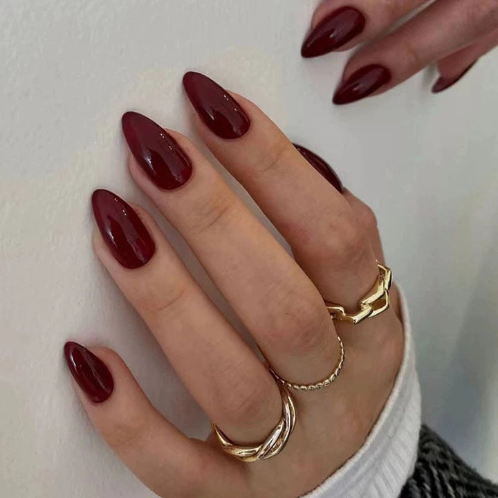 Collection of glossy sharp pointed false nail tips in various colors for trendy women's nail art.