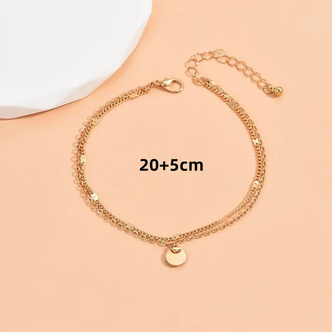 Women's delicate gold layered anklet with charms, perfect for adding elegant touch to summer outfits.