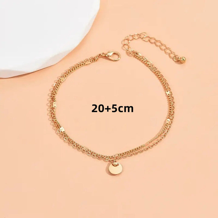 Women's delicate gold layered anklet with charms, perfect for adding elegant touch to summer outfits.