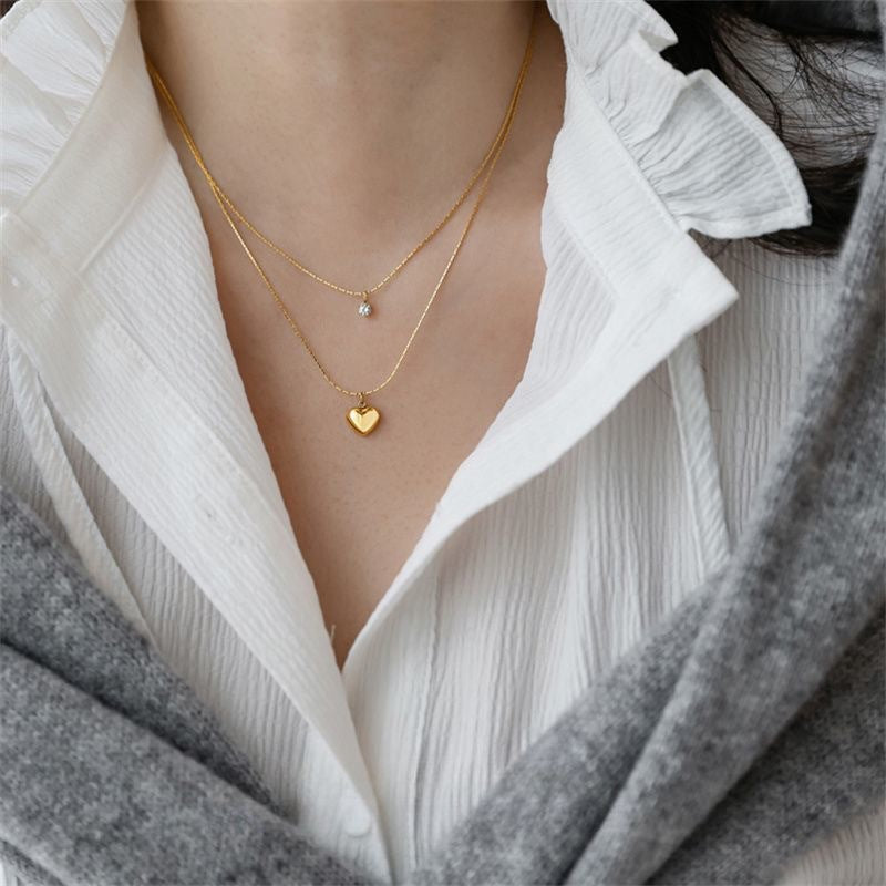 Delicate gold layered necklace for women, featuring a charming heart & a shimmering crystal pendant.