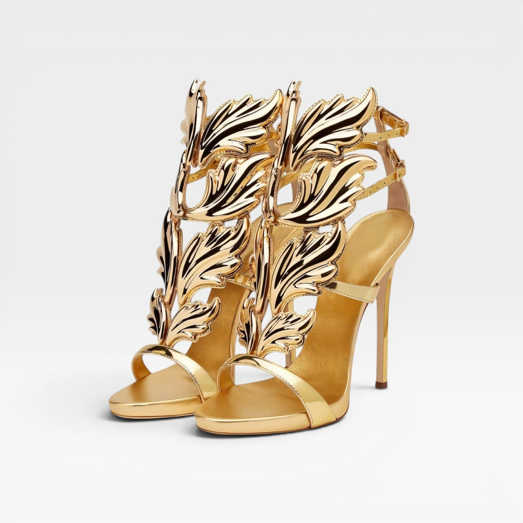 Statement women's gold stiletto sandals featuring unique sculptural wing design, ideal elegant evening footwear.