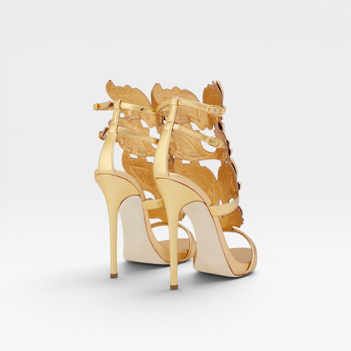 Elegant women's gold metallic high heel sandals with a striking sculptural wing detail, perfect for events.