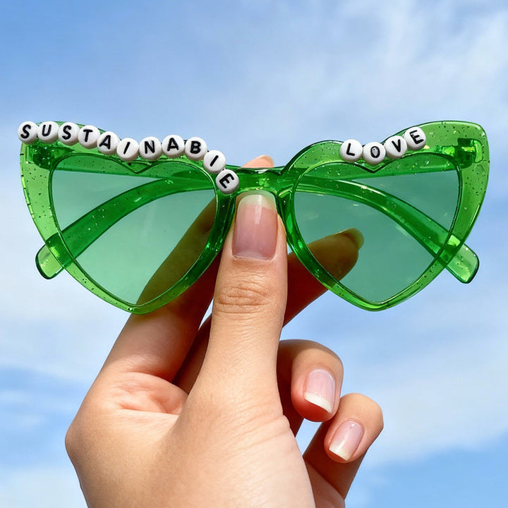 Close-up of women's playful cat-eye sunglasses. Gray retro frame, highlighted by unique beaded accents and UV protection.