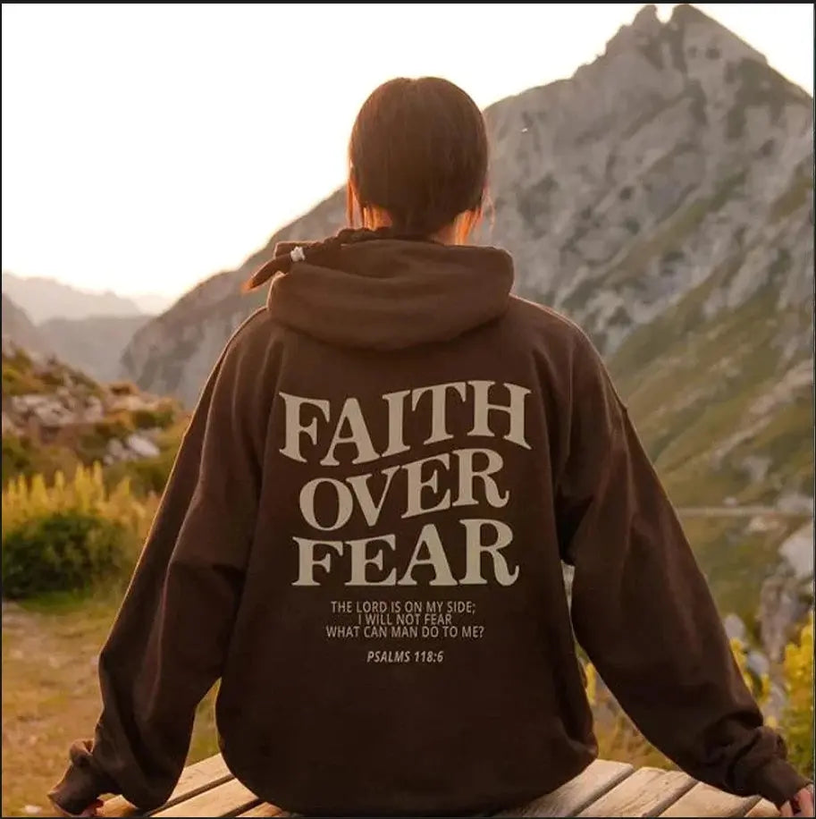 Women's grey "Faith Over Fear" graphic hoodie, close-up of inspirational text.