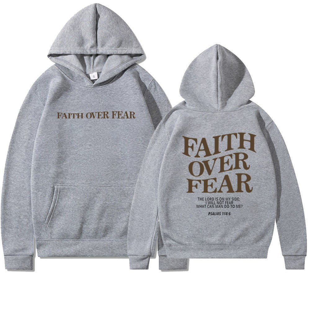 Relaxed woman in stylish "Faith Over Fear" inspirational apparel, casual wear.