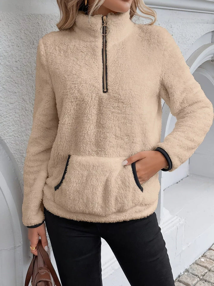 Relaxed fit women's half-zip sweater, warm pullover with a practical front kangaroo pocket.