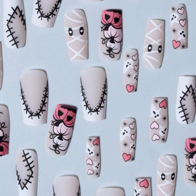 Easy-to-apply women's press-on nails for Halloween, featuring festive spooky nail art and accessories.