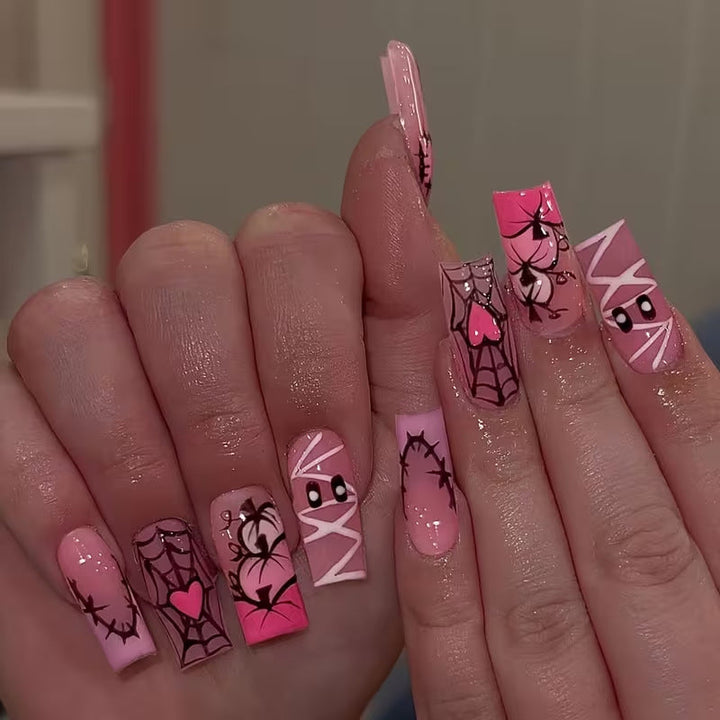 Women's Halloween press-on nails with spooky black art designs for a festive, easy DIY manicure.