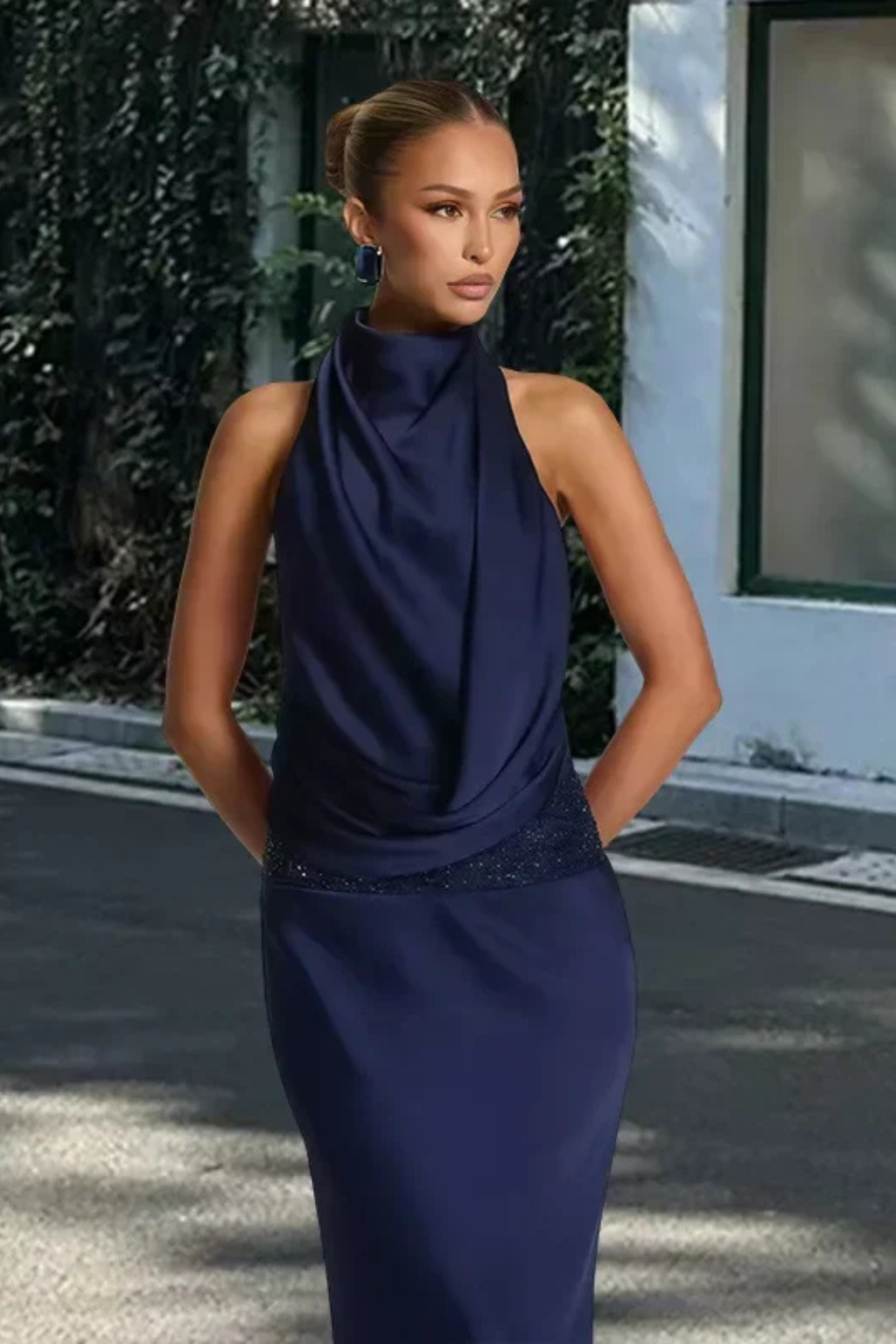 Fashionable women's long party dress with a chic halter neck, draped details, and an open back design.