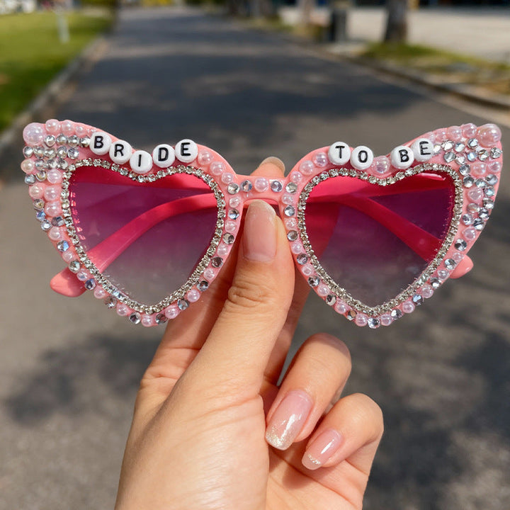 Fashion-forward women's heart-shaped sunglasses, adorned with pearls & rhinestones, UV shield.