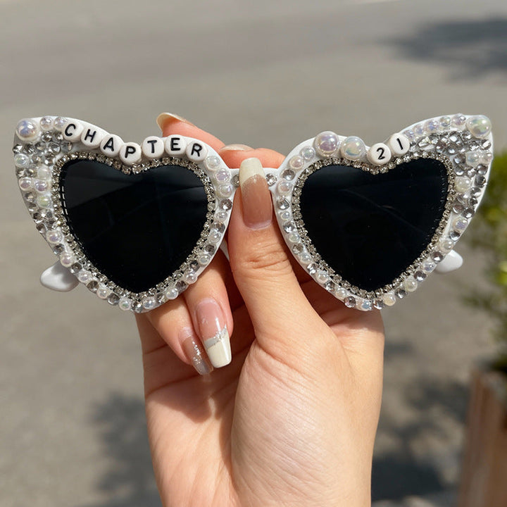 Women's pearl-embellished heart sunglasses. Chic UV protection eyewear for summer outfits.