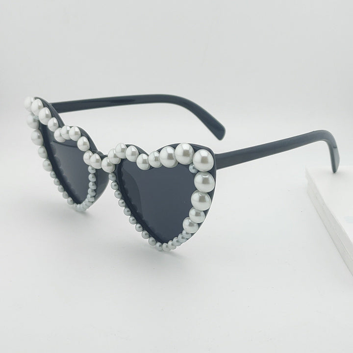 Fashionable women's heart pearl sunglasses, ideal for summer outfits and beach days. Stylish accessory.