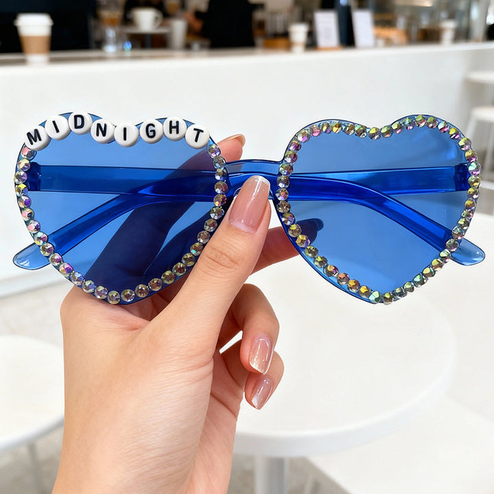 Vibrant heart-shaped rhinestone sunglasses. Stylish women's accessory for a glam and trendy look.