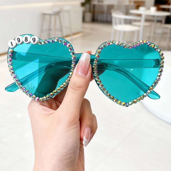 Heart-shaped rhinestone sunglasses for women. Trendy, glamorous, offers UV protection & style.