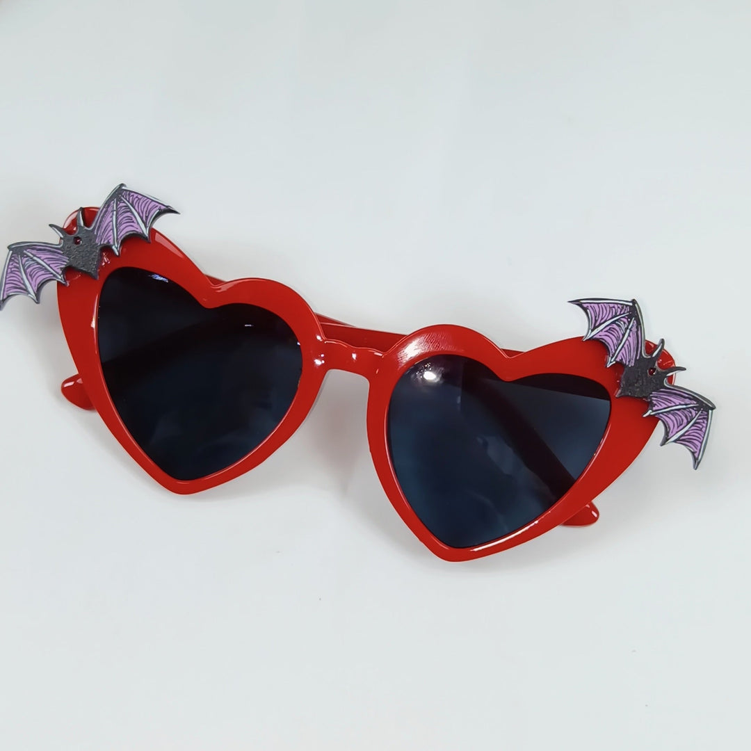 Women's heart-shaped sunglasses with unique bat accents for fashion & UV protection.