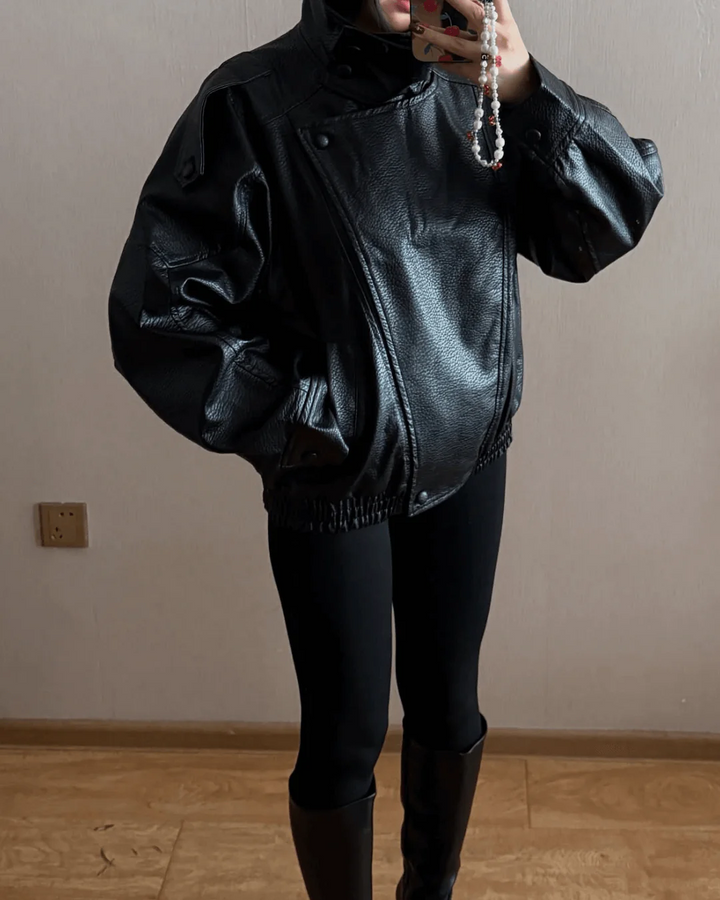 Close-up of women's leather jacket zipper, high neck structured moto style, elegant everyday outerwear.
