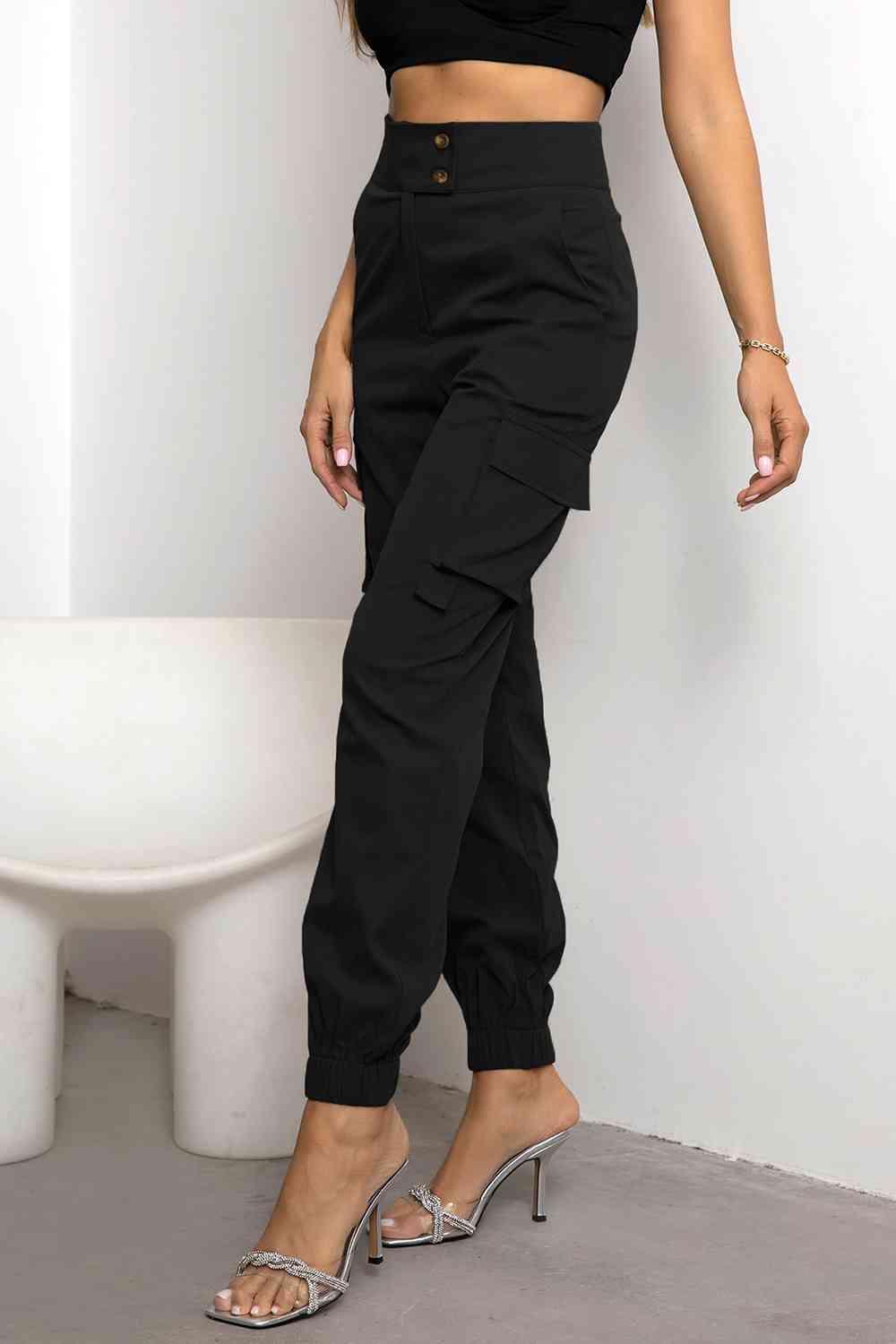 Model wearing comfortable women's black high-waist cargo joggers, showing tapered fit & stylish pockets.