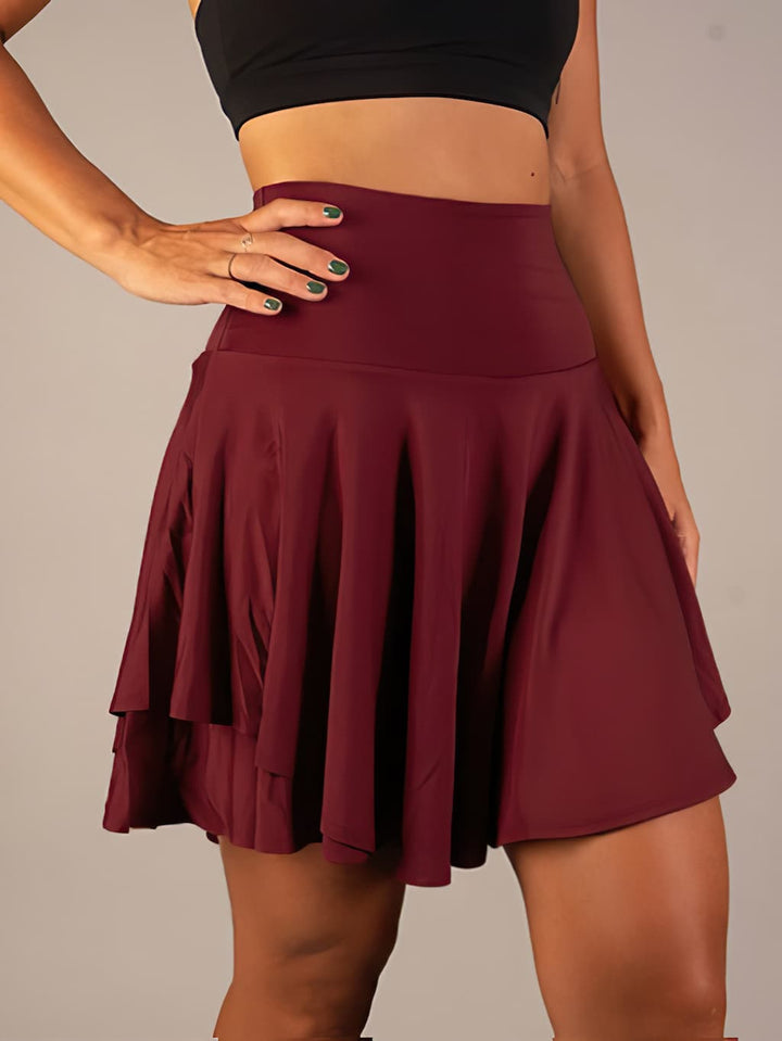 Woman in a high waist flared active skort, ready for tennis practice or a comfortable workout.