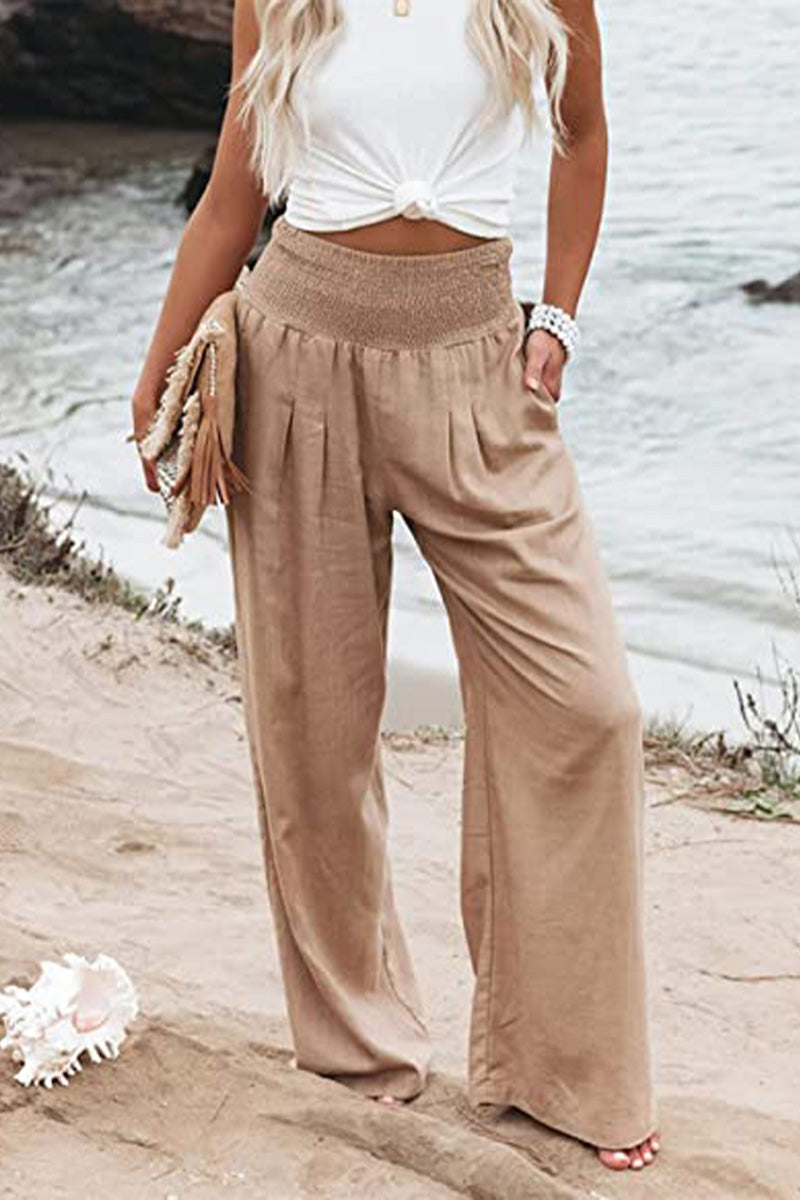 Women's high-waisted smocked wide-leg trousers. Lightweight, flowing fit, comfortable fashion bottoms.