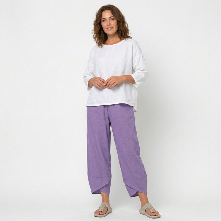 Woman posing in chic high-waisted tulip hem trousers, showcasing modern women's fashion style.