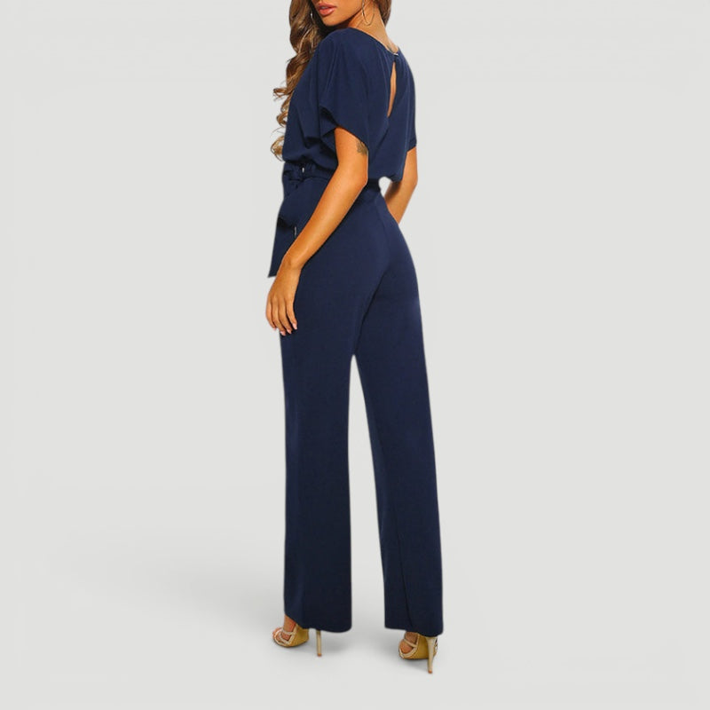 Woman walking in a flowing high waisted wide leg jumpsuit, demonstrating comfort & effortless style for spring.
