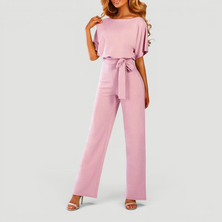 Full length view of a woman wearing a stylish high waisted wide leg jumpsuit, perfect for spring/summer.