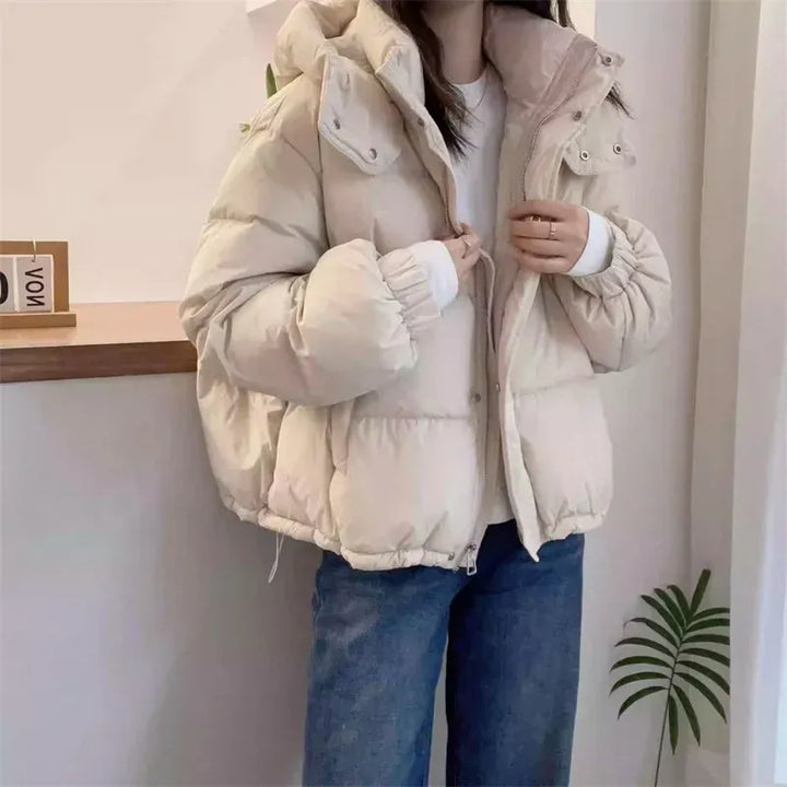 Versatile women's hooded puffer jacket, stylish high neck winter coat for cold climates.