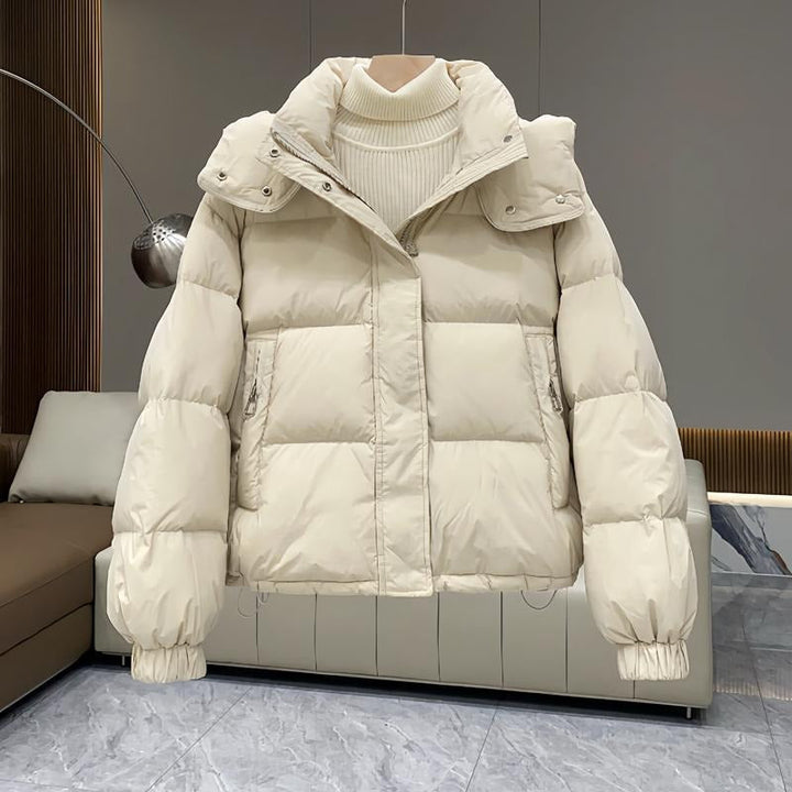 Durable women's hooded puffer jacket, high neck, ensures warmth in harsh winter weather.