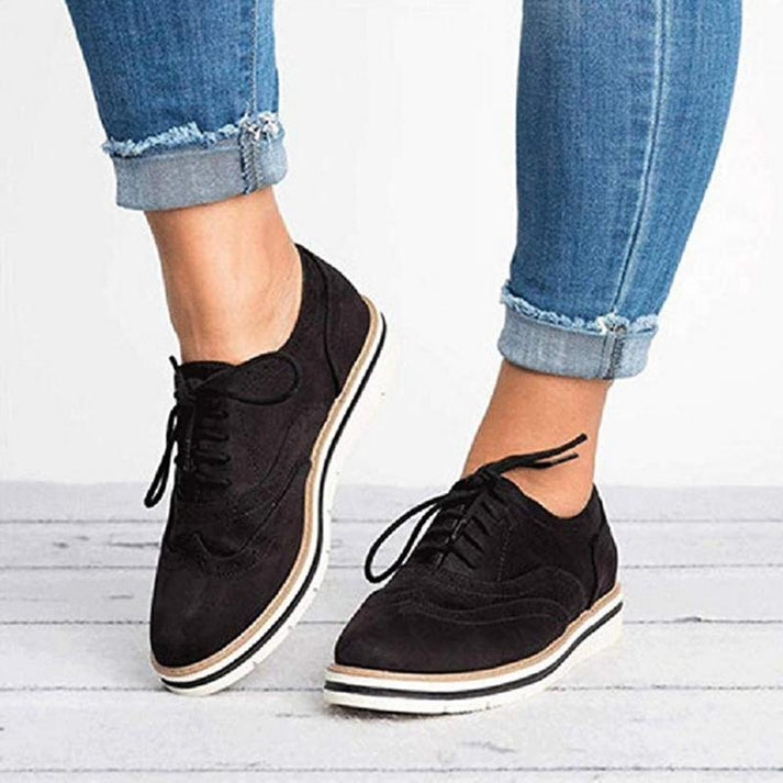 Women's fashion brogue trainers, featuring a flat sole and lace-up design, blending style with all-day comfort.