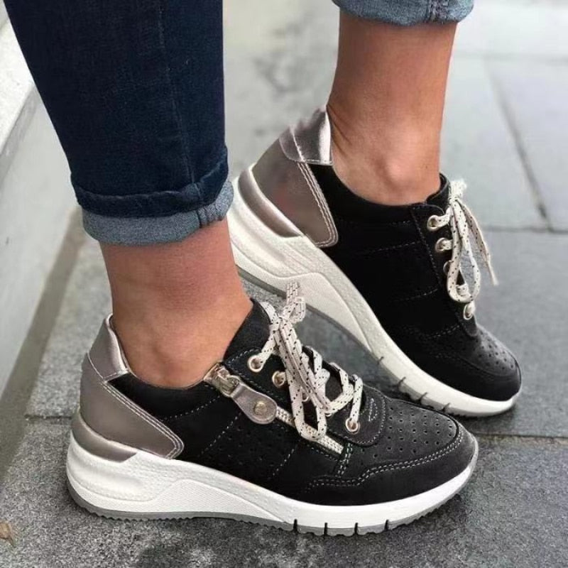 Fashionable & comfortable women's lace-up wedge platform walking sneakers with side zip detail.