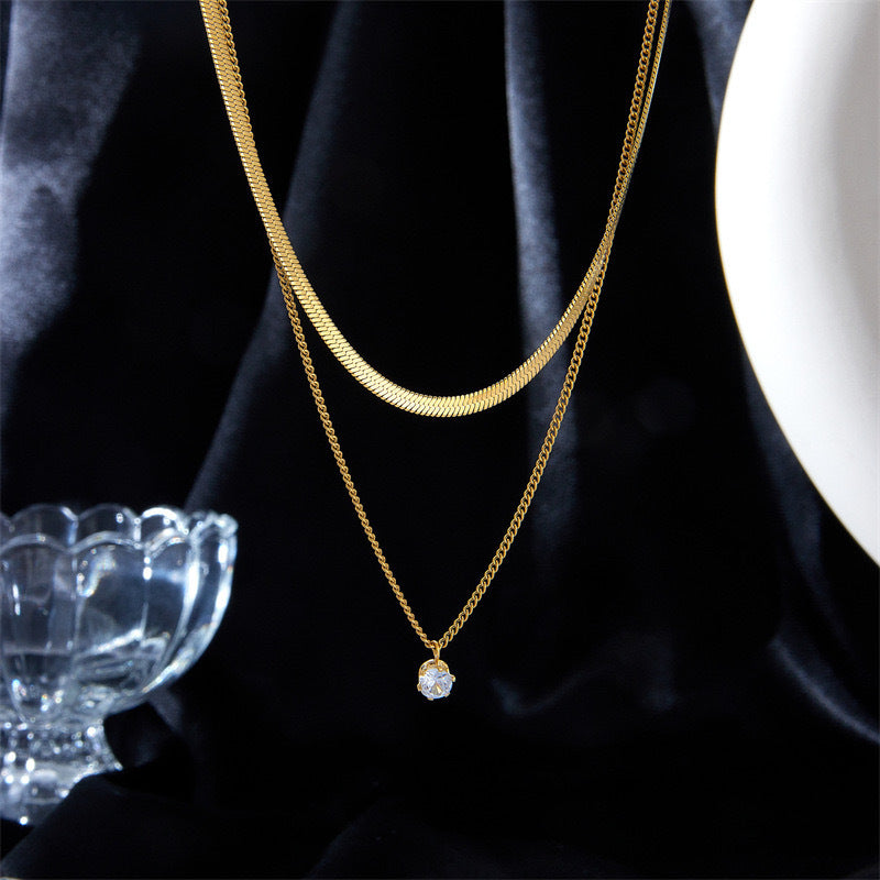 Women's layered dual chain pendant necklace in gold, featuring delicate charms for an elegant look.