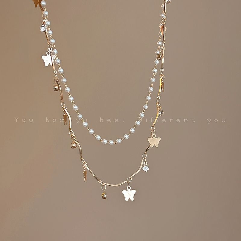 Delicate women's layered necklace with whimsical opal and pearl charms, an elegant statement piece.
