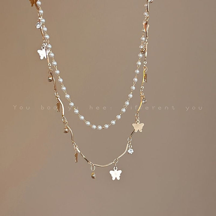 Delicate women's layered necklace with whimsical opal and pearl charms, an elegant statement piece.
