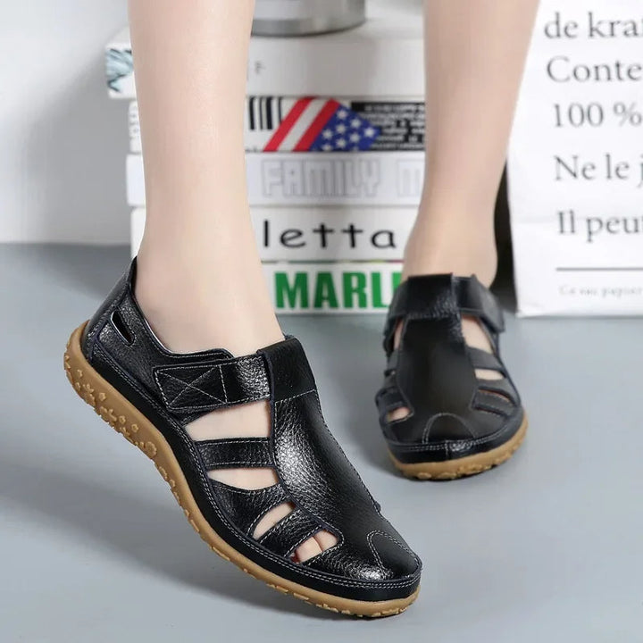 Stylish women's slip-on leather sandals with hook-and-loop closure for adjustable comfort.