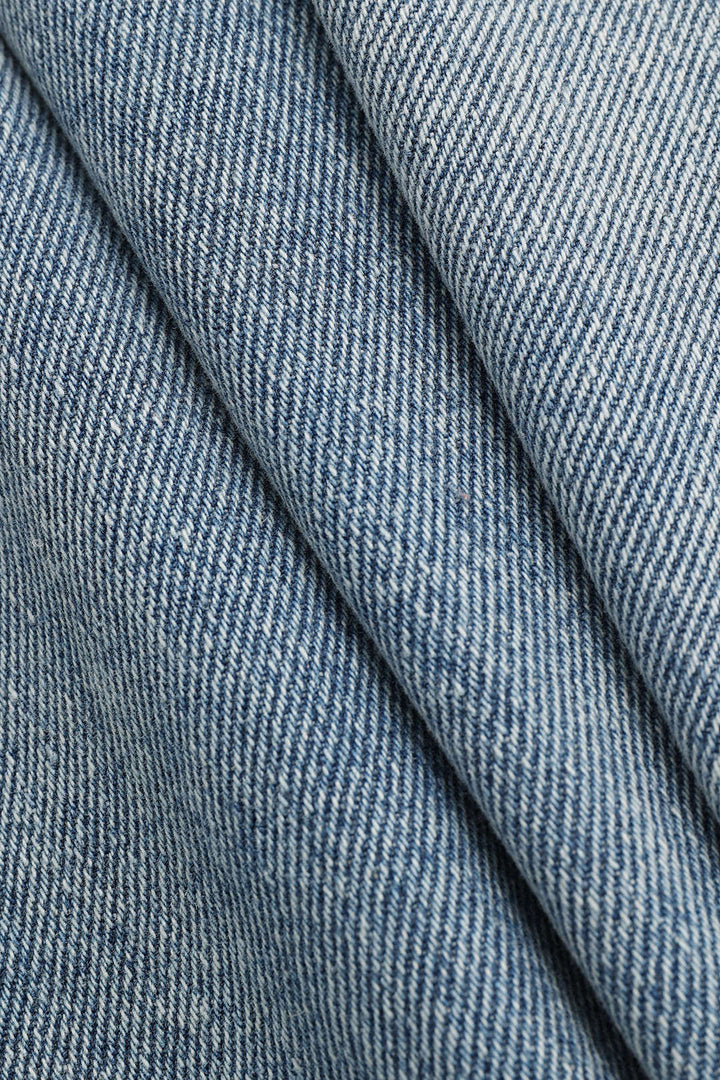 Stylish women's high-waisted straight-leg jeans in light wash, featuring an asymmetric detail for edgy fashion.