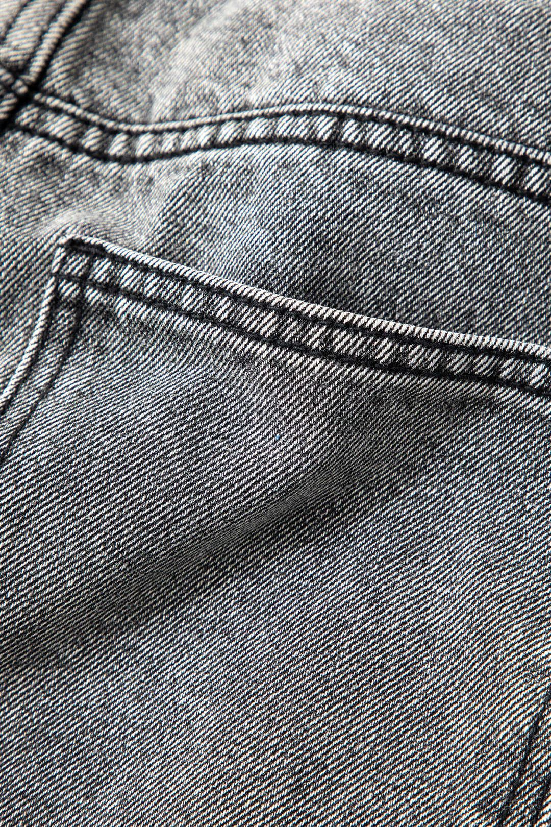 Distinctive women's asymmetric high-waisted straight-leg jeans in a light wash for an edgy, modern aesthetic.