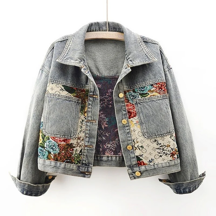 Women's light wash denim jacket with vibrant floral embroidery, perfect for stylish spring & fall outerwear.