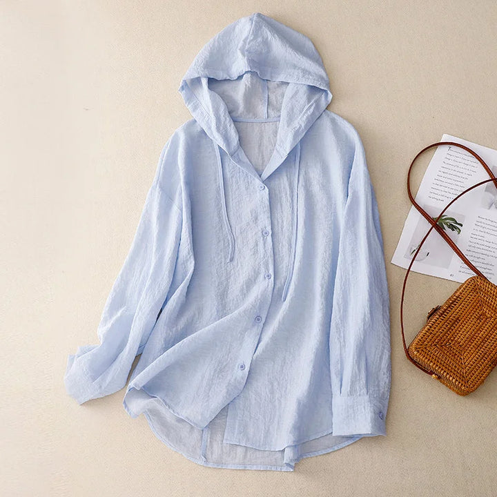 Woman wearing a lightweight crinkled button-front hoodie with drawstring hood, ideal for comfortable, casual summer outfits.