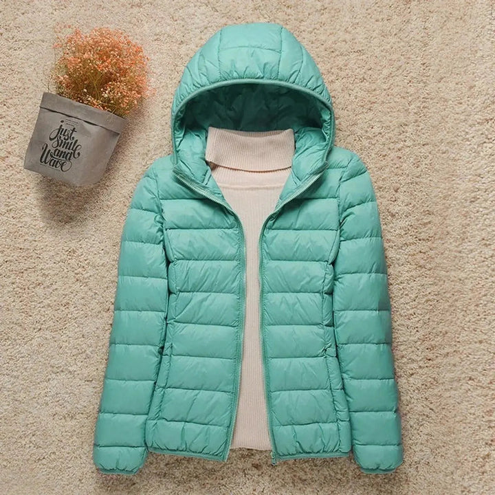 Modern women's lightweight hooded puffer. Quilted and packable design, ideal versatile casual outerwear.
