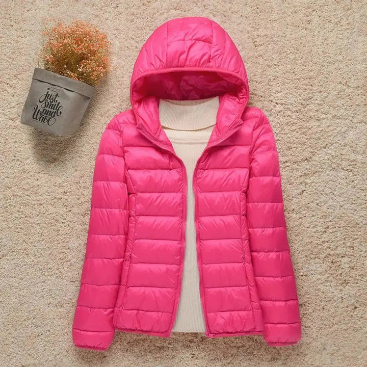 Elegant women's hooded puffer, quilted for warmth. Lightweight & packable, a versatile travel jacket.